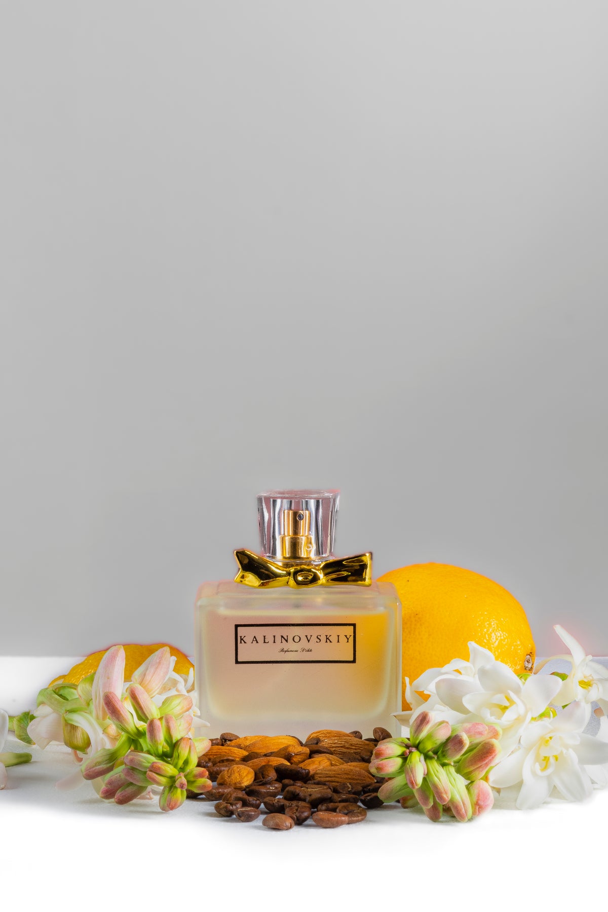 Frasco de Heaven junto a cítricos, café y flores blancas.